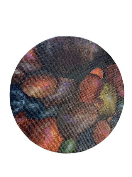 Circular canvas with stones in warm reds, greens, and purples